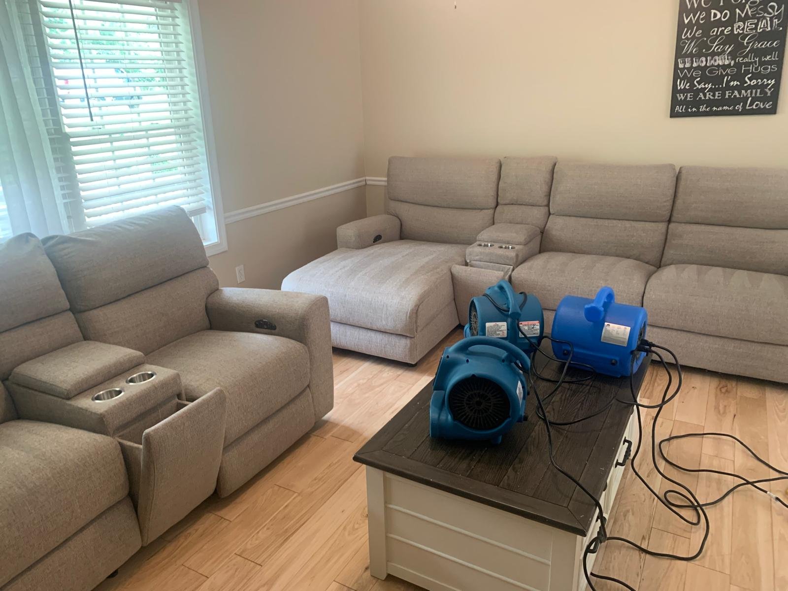 Beige reclining sectional sofa drying under air movers after upholstery cleaning